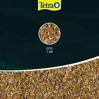 Tetra visvoer, detail van korrelgrootte met schaal: 1 cm. Bovenaan zichtbaar Tetra merknaam.