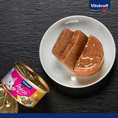 Vitakraft Poésie Mousse csirkével tányéron, mellette felnyitott konzerv. Termékbemutató nedves eledelhez.