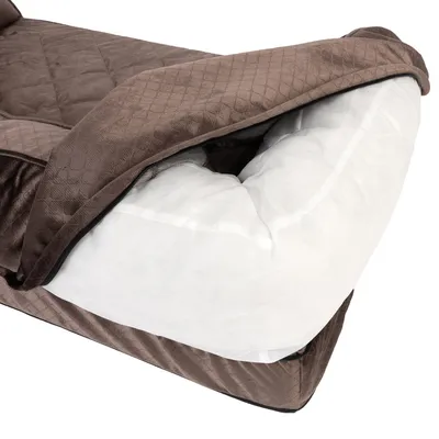 Primer plano de una cama para perro marrón con funda extraíble y relleno interior blanco acolchado.