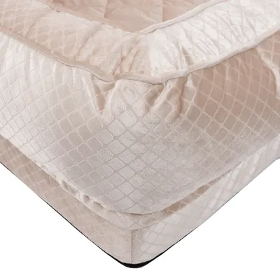 Primer plano de una cama de tela beige acolchada con patrón de rombos y superficie suave.