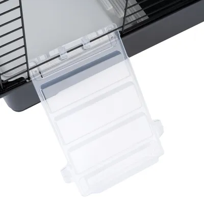 Rampe en plastique transparent fixée à l'entrée d'une cage pour petits animaux, vue de dessus montrant les détails des attaches et des barreaux métalliques.
