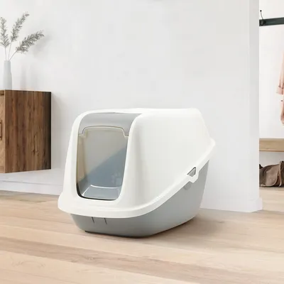 Caja de arena cerrada para gatos con tapa blanca y base gris, puerta abatible con motivo de huellas.