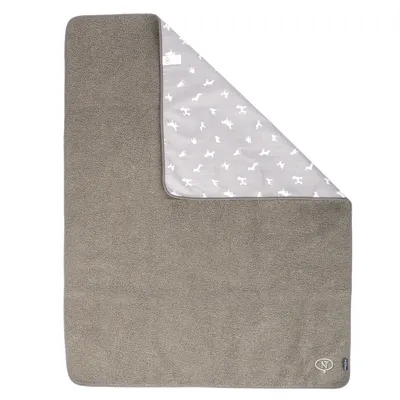 Couverture grise pour animaux, une face en tissu peluche et une face grise à motifs silhouettes blanches de chiens et chats, coin replié, étiquette visible avec logo NT.
