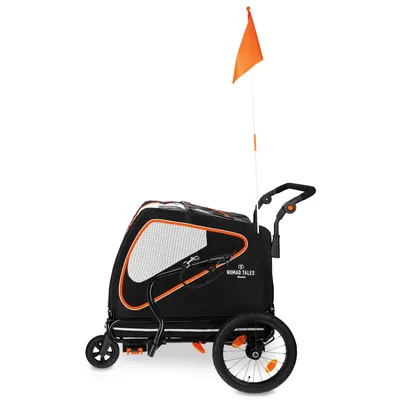 Nomad Tales cykelvagn med svart tyg, orange detaljer, nätfönster och säkerhetsflagga. Två stora hjul och justerbart handtag synliga.