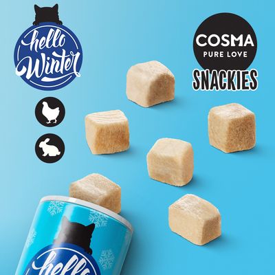 Cosma Pure Love Snackies, embalagem azul com cubos de snack visíveis. Texto: hello Winter. Ícones de galinha e coelho presentes na imagem.