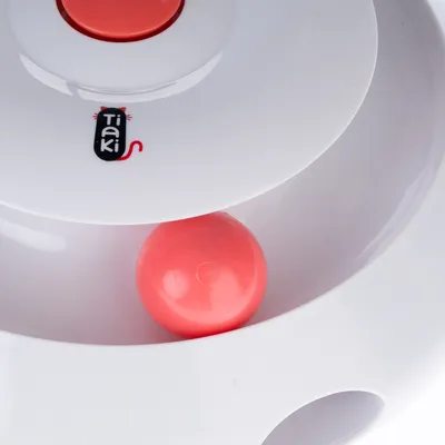 Tiaki juguete con carcasa de plástico blanca y bola roja, apto para juego interactivo.