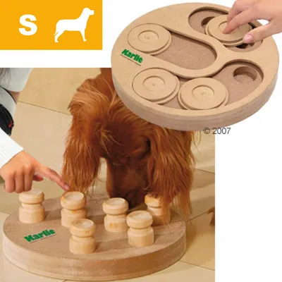 Hund leker med Karlie träpussel, rund form med flyttbara delar. Hand visar hur spelet används. Gul ikon med bokstaven S och hundsilhuett syns i hörnet. Hund leker med Karlie träpussel, rund form med flyttbara delar. Hand visar hur spelet används. Gul ikon med bokstaven S och hundsilhuett syns i hörnet.
