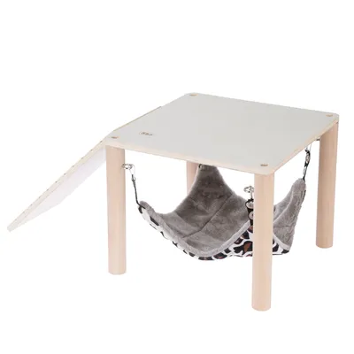 Holztisch mit weisser Oberfläche und integrierter Hängematte aus grauem Plüsch mit Leopardenmuster, befestigt an Metallhaken unter der Tischplatte. Holztisch mit weisser Oberfläche und integrierter Hängematte aus grauem Plüsch mit Leopardenmuster, befestigt an Metallhaken unter der Tischplatte.