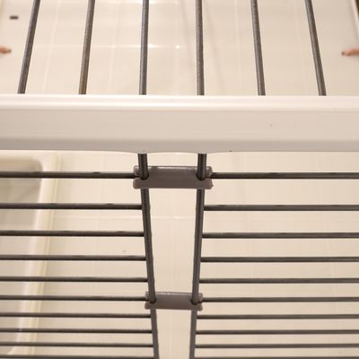 Close-up view of a metal grid with grey connectors and a white frame, suitable for cages or enclosures.