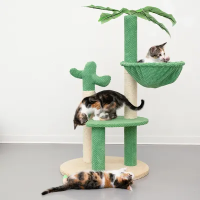 Cat tree with green design, palm and cactus elements. Three cats playing on different levels of the cat tree.