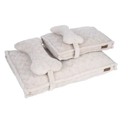 Deux couvertures en tissu beige pliées, chacune maintenue par une sangle avec un coussin en forme d’os. Étiquette visible : 'Modern Living'. Deux couvertures en tissu beige pliées, chacune maintenue par une sangle avec un coussin en forme d’os. Étiquette visible : 'Modern Living'.