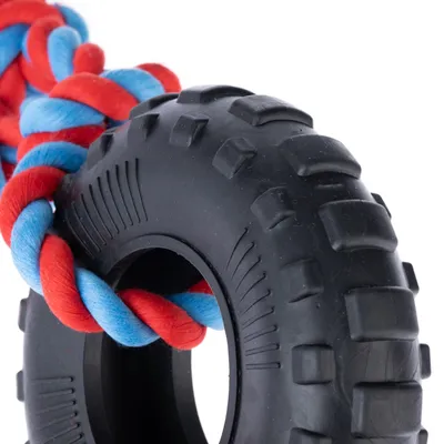 Giocattolo in gomma nera a forma di pneumatico con corda intrecciata rossa e blu.