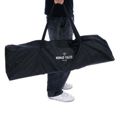 Nomad Tales München bärväska, svart, med handtag, bärs av en person.