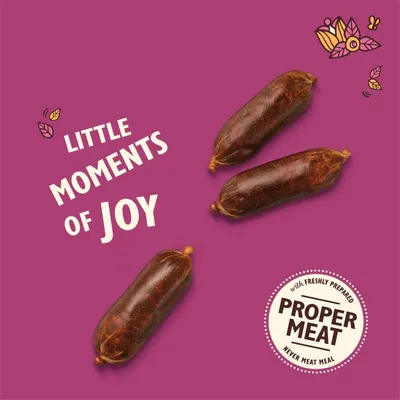 Three sausage-shaped treats with the text 'Little moments of joy' and a badge stating 'with freshly prepared proper meat, never meat meal'.