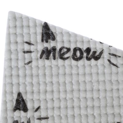 Nærbillede af hvidt, struktureret materiale med sort tekst 'meow' og katteøre-symboler.