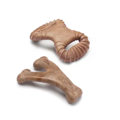 Deux jouets à mâcher pour chien en forme d’os, l’un avec inscription « PUPPY », l’autre avec inscription « Benebone », matériau marron aspect plastique.