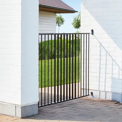 Cancello di sicurezza in metallo nero installato tra due muri bianchi, adatto per delimitare spazi esterni come giardini o cortili.
