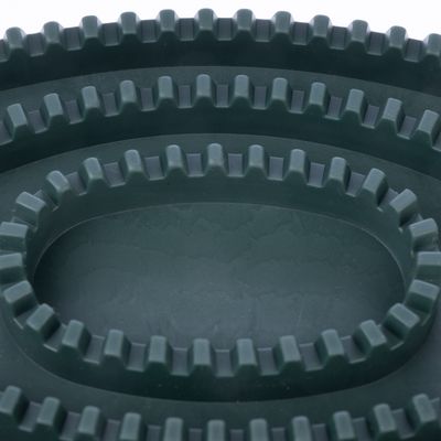 Primo piano di un anello di gomma verde scuro con bordi dentellati, adatto per masticare o giocare.