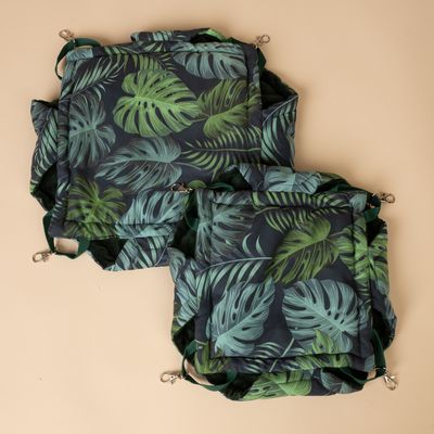 Hängmatta med tropiskt bladmotiv, mörkgrön och ljusgrön på svart bakgrund, med metallclips för fastsättning.