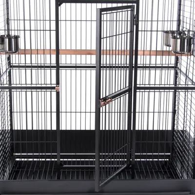 Cage en métal noir avec porte, deux gamelles en acier inoxydable et perchoir en bois à l'intérieur.