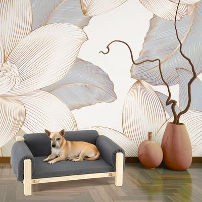 Träsäng för hund med grå tygklädsel, dekorerad mot blommig bakgrund. Hunden ligger avslappnad på sängen.