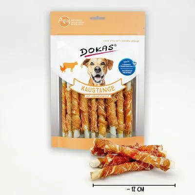 Verpakking Dokas Kaustange mit Hühnerbrust, transparant met zichtbare kauwstaven. Tekst: 'Kaustange mit Hühnerbrust', lengte-indicatie ca. 12 cm onderaan.
