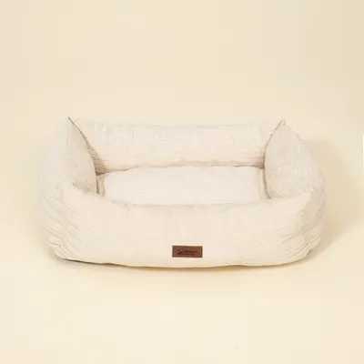 Letto rettangolare, beige chiaro con struttura in tessuto e etichetta marrone con la scritta 'Modern Living' sul lato anteriore.