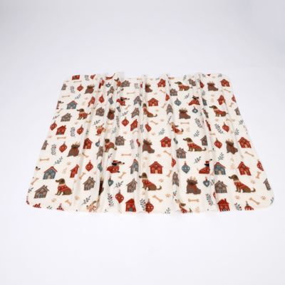 Coperta con motivo colorato di casette per cani, cani, ossa e foglie su sfondo bianco.