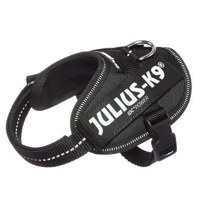 Sort hundesele med teksten JULIUS-K9 IDC®POWER, synlige spænder og metalring. Materiale: tekstil og plastik.
