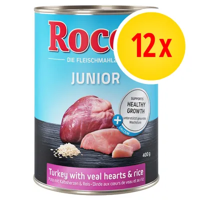 Rocco Junior, 12 x 400 g, tacchino con cuori di vitello e riso. Testo visibile: Supports healthy growth, calcium. Immagine di carne e riso sulla confezione.