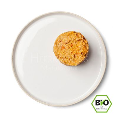 Porcija mokre hrane za hišne ljubljenčke na belem krožniku, v spodnjem desnem kotu je BIO znak z napisom 'BIO nach EG-Öko-Verordnung'.