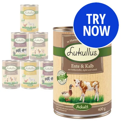Selection of Lukullus adult food tins in various flavours, with a large can labelled duck and veal, sweet potato, apple and linseed oil. Blue circle with white text: Try Now.
