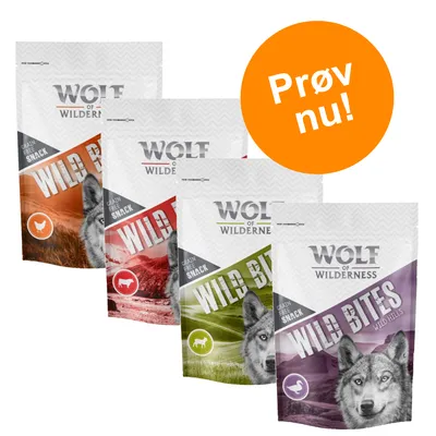 Fire poser Wolf of Wilderness Wild Bites hundesnacks med forskellige varianter. Tekst på orange cirkel: Prøv nu! Synlig tekst: Grain Free Snack, Wild Bites.