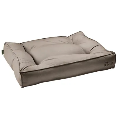Coussin rectangulaire beige pour chien, marque HUNTER visible sur le coin avant droit, tissu à texture fine, bords épais rembourrés.