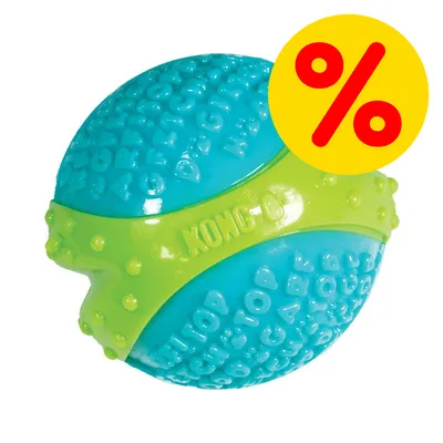 Palla per cani KONG in plastica blu e verde con superficie testurizzata, simbolo percentuale rosso su sfondo giallo visibile nell'angolo in alto a destra.