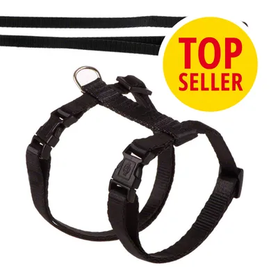 Černý nylonový postroj s plastovými přezkami a kovovým kroužkem, v pravé části žlutý kruh s červeným textem TOP SELLER.
