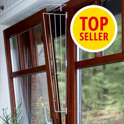 Bílá kovová ochranná mříž na vyklápěcím okně, žlutý kruh s červeným textem TOP SELLER v pravém horním rohu