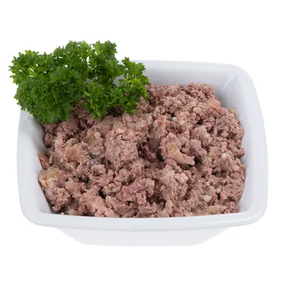 Schale mit zerkleinertem Fleisch und frischer Petersilie als Garnitur.