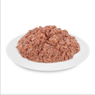 Közelkép aprított húsról fehér tányéron, alkalmas állateledelhez.