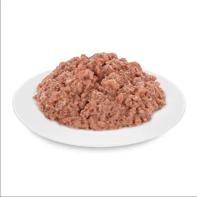 Közelkép aprított húsról fehér tányéron, alkalmas állateledelhez.