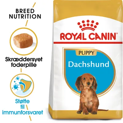 Royal Canin Puppy Dachshund hundefoder, tekst: Breed Nutrition, Skræddersyet foderpille, Støtte til immunforsvaret. Billede af foderpille og gravhundehvalp på posen.