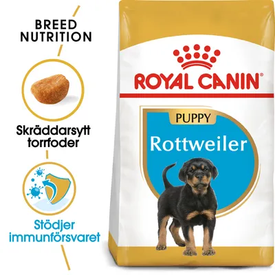 Royal Canin Puppy Rottweiler torrfoder, skräddarsytt foder, stöder immunförsvaret. Bild på en rottweilervalp och foderbit. Text: Breed Nutrition.