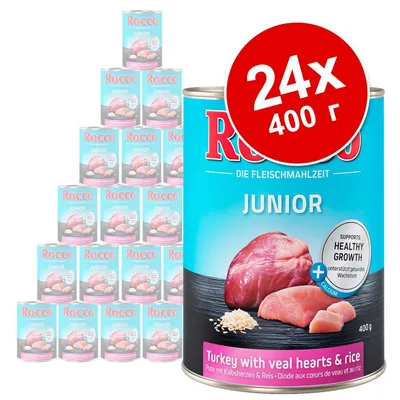 24 банки по 400 г Rocco Junior, индейка с телячьими сердцами и рисом. Видна надпись: Supports healthy growth + calcium. Упаковка голубого цвета.