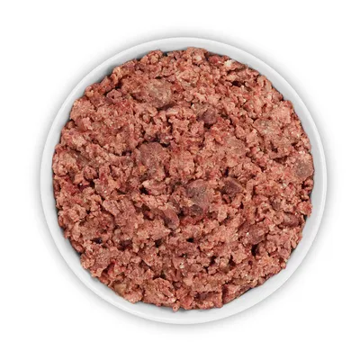 Primer plano de carne cruda picada en un cuenco blanco. Imagen de producto para alimento para animales.