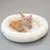 Two kittens sitting in a white, round pet bed made of soft material.