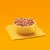 Bowl filled with cubed wet pet food placed on a folded yellow cloth, showing product texture and serving suggestion.