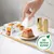 Gourmet Revelations Mousse mit Huhn, 2x Portionspackungen. Hand zeigt Entnahme der Verpackung. Hinweis: Zum Recyceln bestimmt.