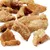 Gedroogde stukjes varkenshuid, goudbruin en knapperig, geschikt als snack voor huisdieren.