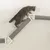 Graue Katze auf einer Wandmontage-Kratzbaumkonstruktion mit Sisal umwickelten Kratzstämmen und weissen Halterungen.