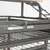 Détail d’une cage pour oiseaux en métal avec plateau amovible, perchoir en bois et échelle métallique visibles sur la partie supérieure.